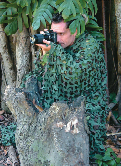 Fotograf v maskovacej sieti pre dokonalé maskovanie v prírode